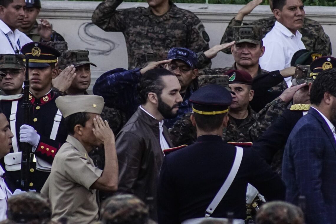 Members of El Salvador’s military salute as President Nayib Bukele walks past.
