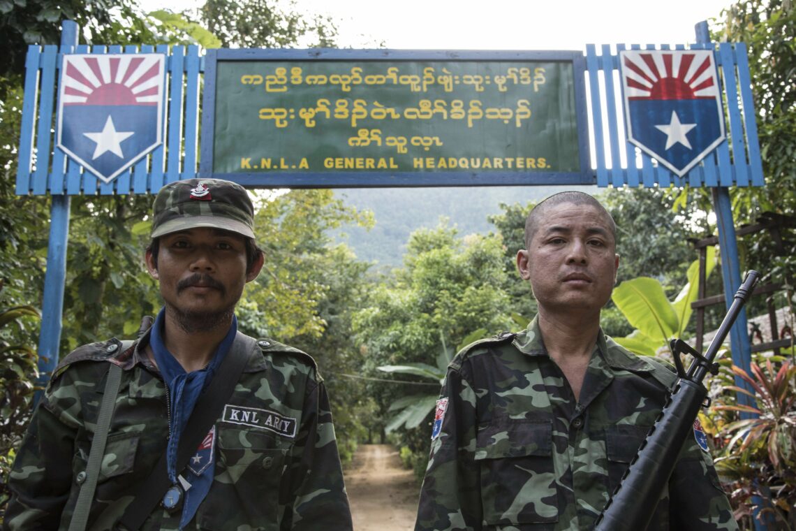 Soldiers from the Karen National Liberation Army (KNLA) stand in front of the army's headquarters