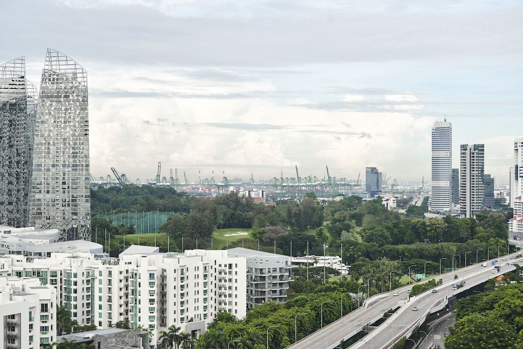 A picture of Singapore city with port cranes the horizon