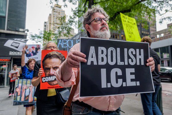 The activist group Rise and Resist holding signs that read “Abolish I.C.E.”