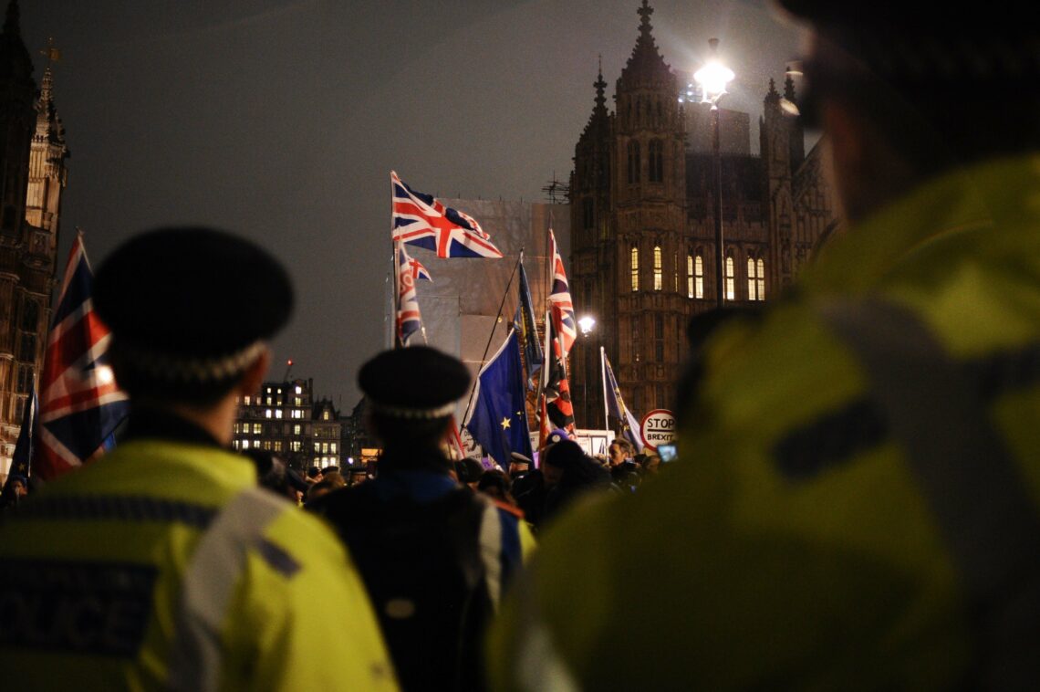 Police officers watch as opponents and supporters of Brexit demonstrate in London