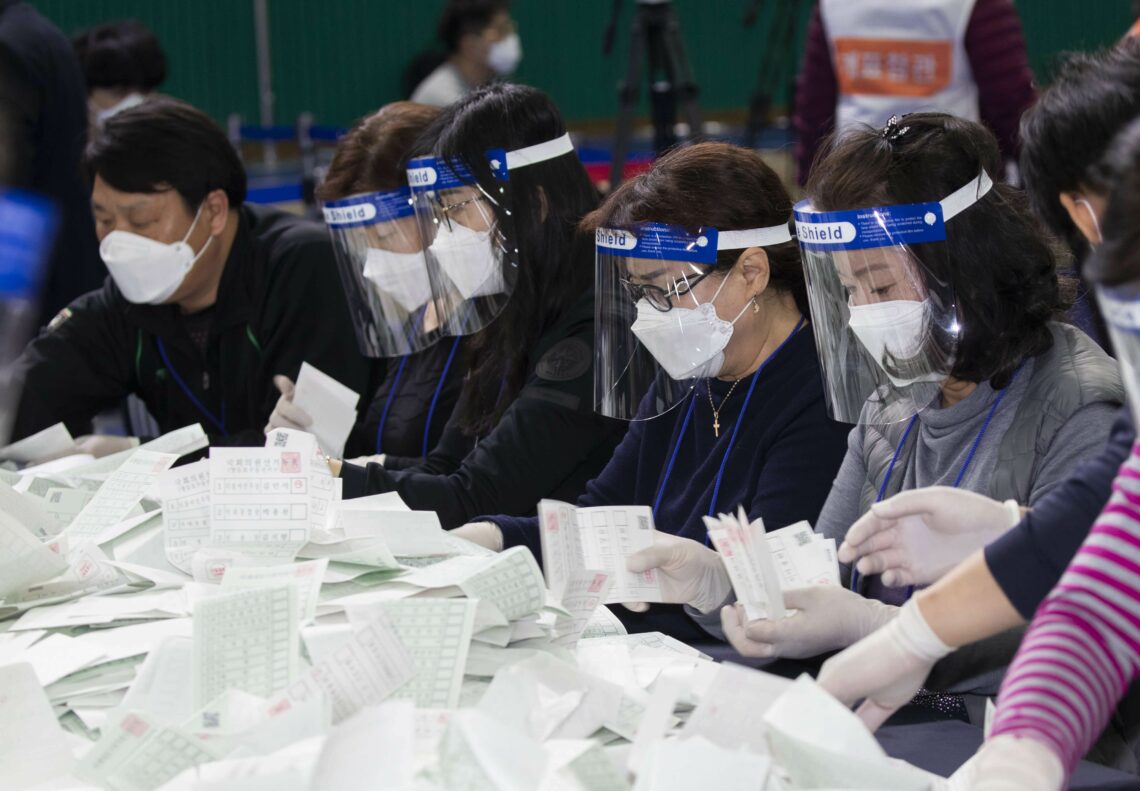 Staff count ballots at a voting station in South Korea
