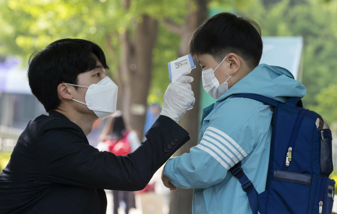 Teacher measuring the body temperature of a student in Seoul, South Korea