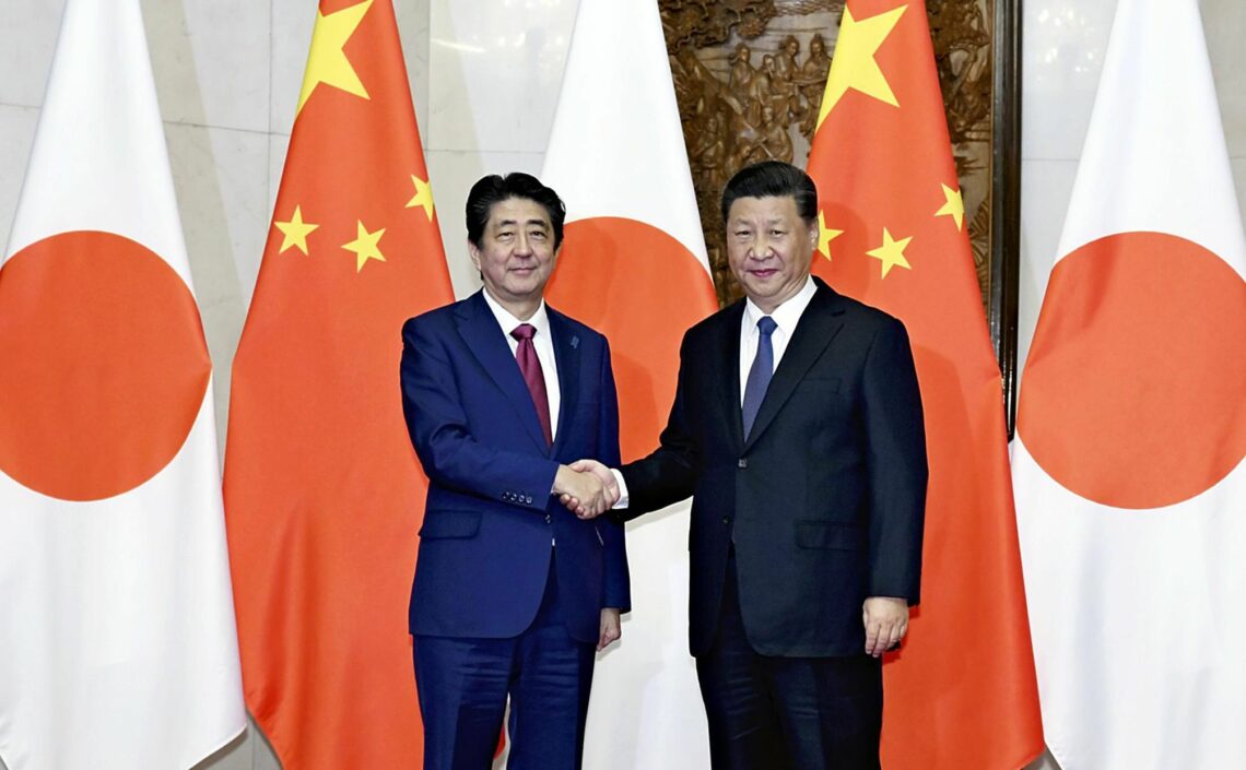 Japanese Prime Minister Shinzo Abe and Chinese President Xi Jinping shake hands
