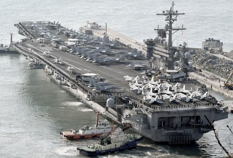 A picture of a U.S. nuclear-powered aircraft carrier being tugged to port