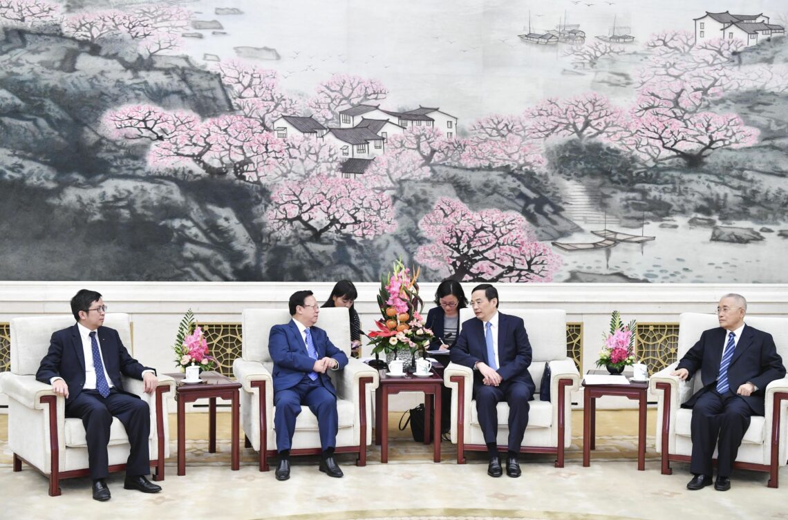 Chinese and Vietnamese officials sit for a photo during a meeting in 2018