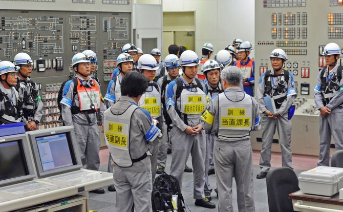 Workers at Japanese power utility prepare for disaster drill in control room