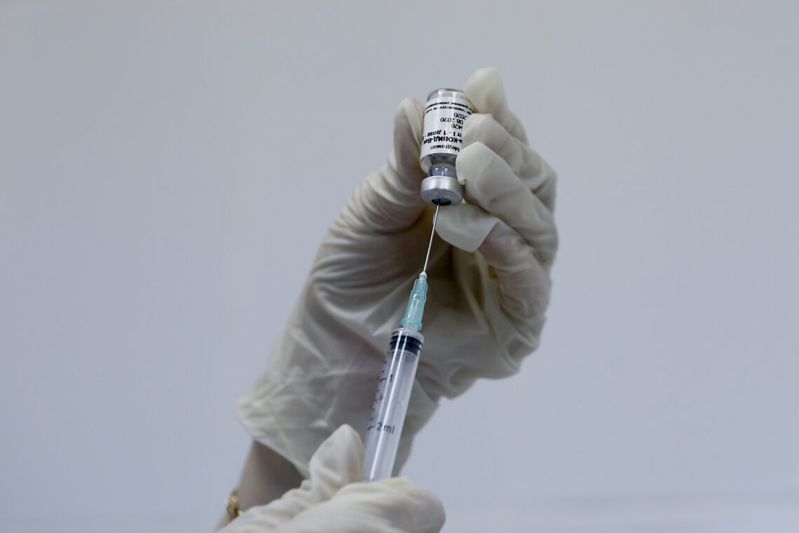 A medical worker prepares a syringe with a Russian test vaccine for Covid-19