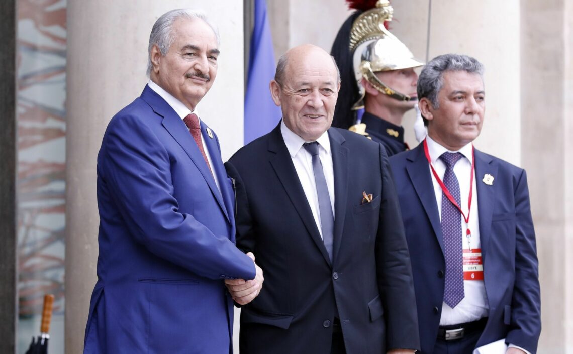 Field Marshal Khalifa Haftar shakes hands with French Foreign Minister Jean-Yves Le Drian