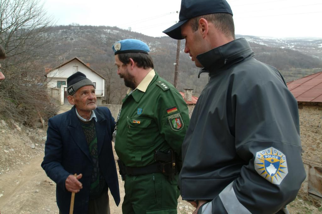 A picture of a Kosovar meeting of two members of the international police patrol in the village of Orcusa near the border with Albania