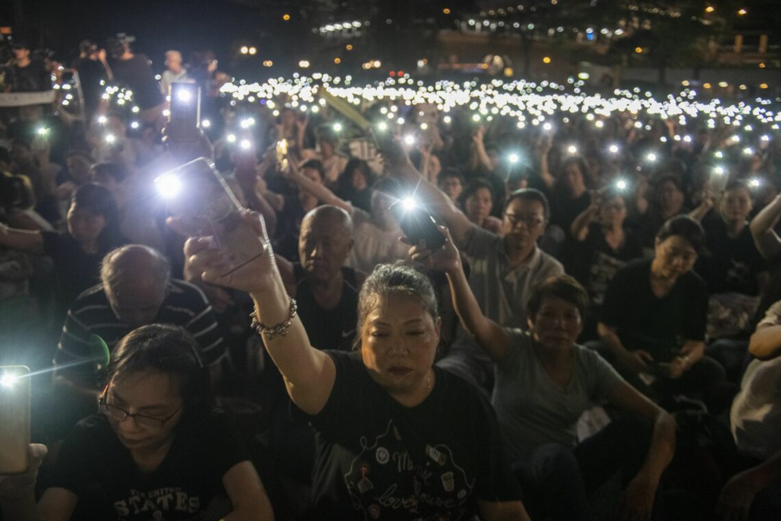 Hong Kong protestors hold up their phones with their flashlights on