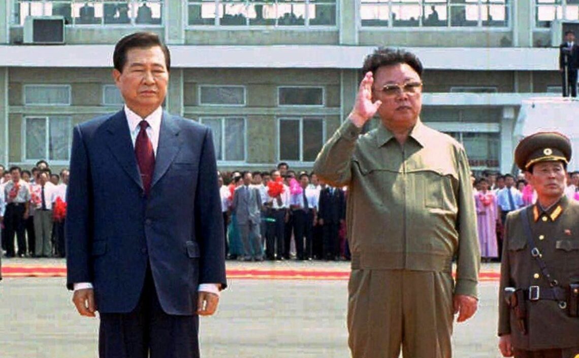 South Korean President Kim Dae-jung and North Korean leader Kim Jong-il stand together at the airport in Pyongyang, June 13, 2000