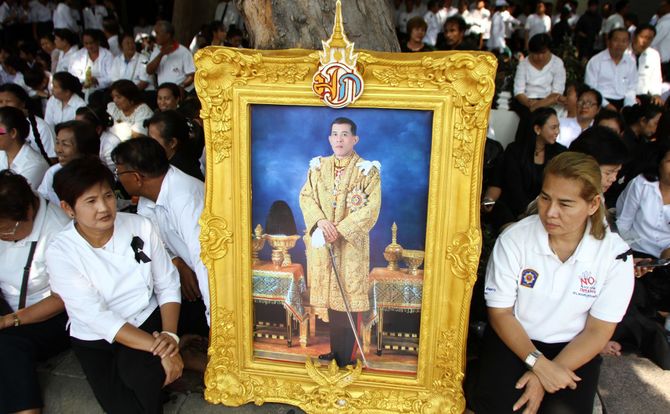 Participants in a Buddhist merit-making ceremony in Bangkok display a portrait of King Maha Vajiralongkorn