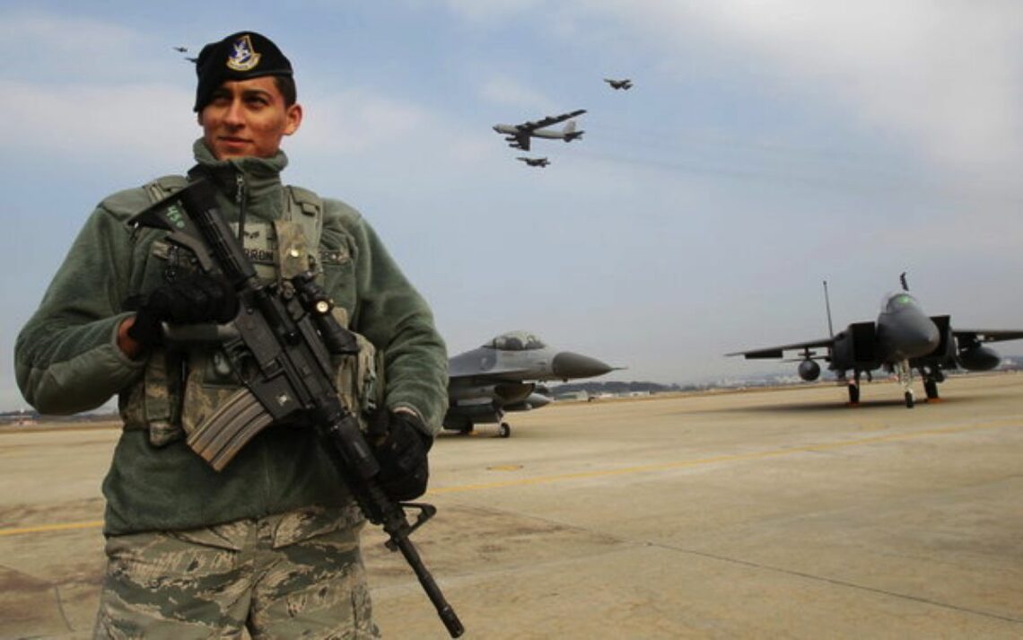 Soldier stands guard as B-52 overflies a U.S. air base in South Korea