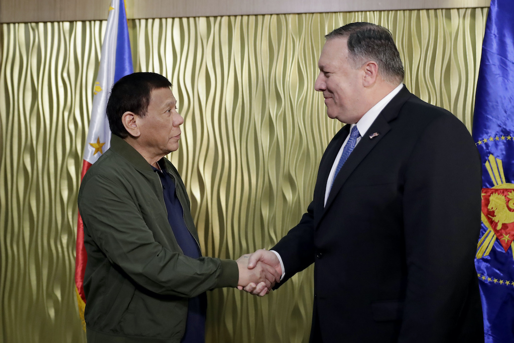 The leader of the Philippines and the head of U.S. diplomacy exchange a handshake
