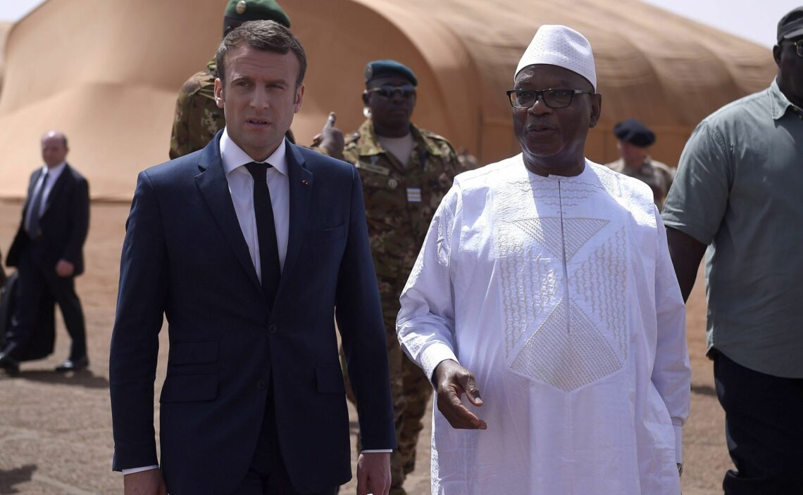 French President Emmanuel Macron (L) and Malian President Ibrahim Boubacar Keita (R) review troops during a visit to France’s counterterrorism operation in Gao, northern Mali, in May 2017