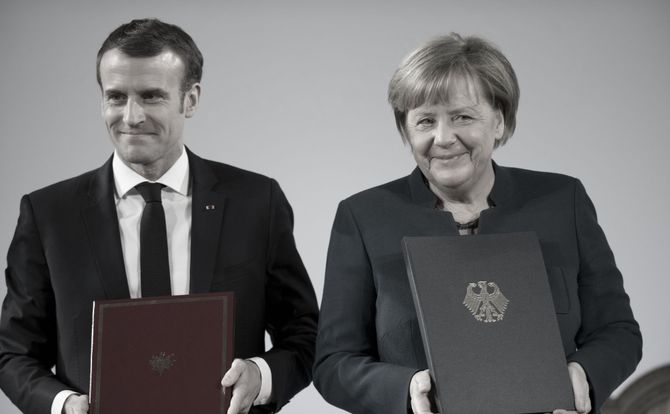 French President Emmanuel Macron and German Chancellor Angela Merkel pose for photos after signing their new treaty in Aachen