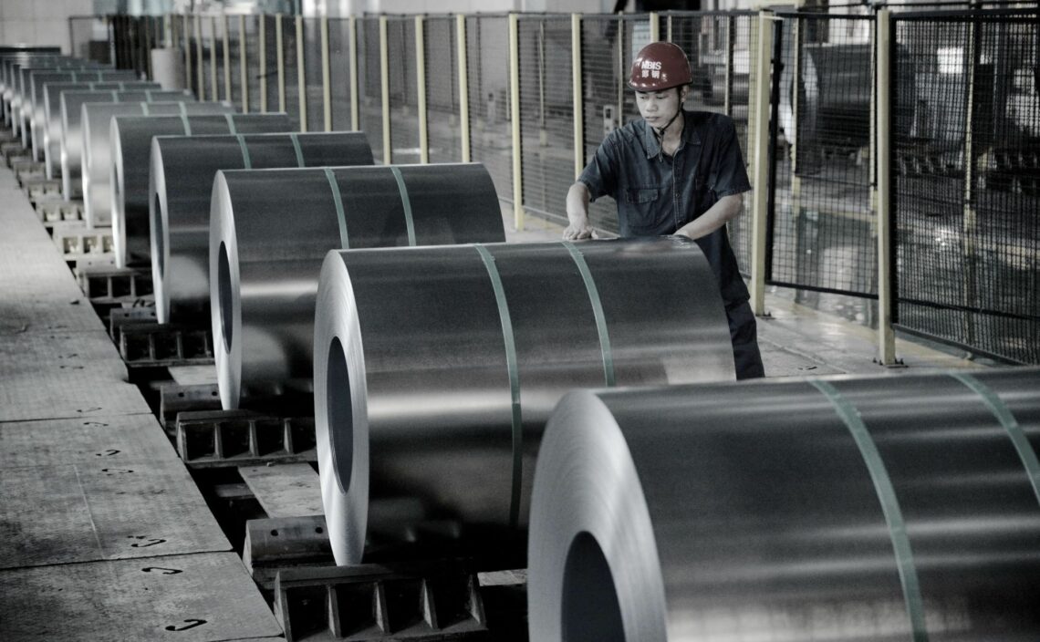 A Chinese worker checks rolls of coiled steel sheet at a steel plant in Handan city, in northern China