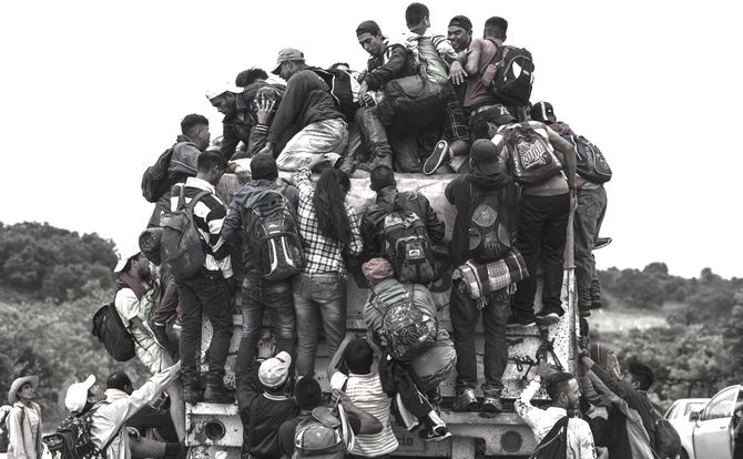 Central American migrants hitch a ride on an overloaded truck in Mexico