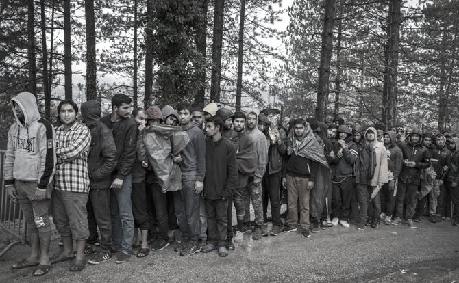 Pakistani and Afghan migrants line up at the Croatian border with Bosnia and Herzegovina