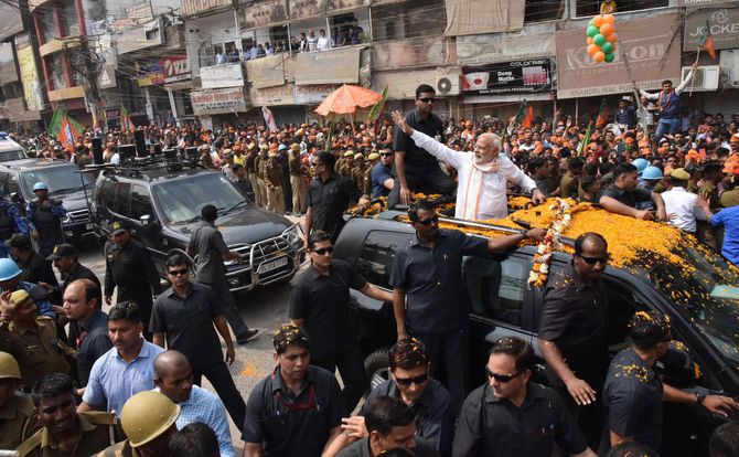 Indian Prime Minister Narendra Modi waves to supporters during a March 2017 campaign parade for the state assembly elections