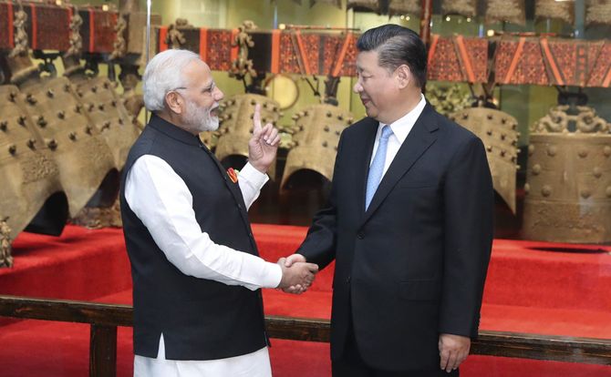 Indian Prime Minister Narendra Modi (L) and Chinese President Xi Jinping shake hands in a museum in Wuhan, China