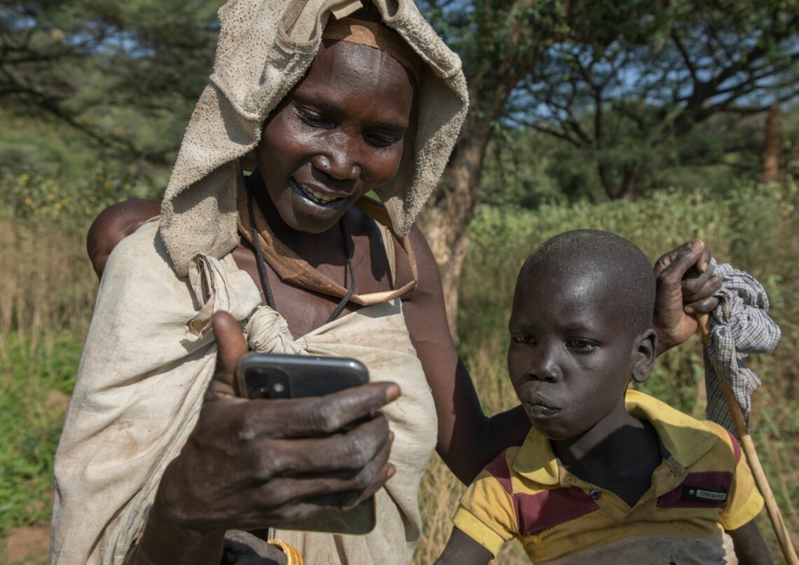 A mother and son use a mobile phone in South Sudan