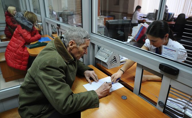 Retired man fills out forms at Russian Pension Fund office in Ryazan