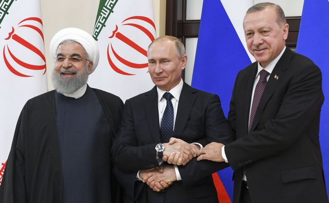 Iranian President Hassan Rouhani, Russian President Vladimir Putin and Turkish President Recep Tayyip Erdogan shake hands in Sochi, Russia, during a summit