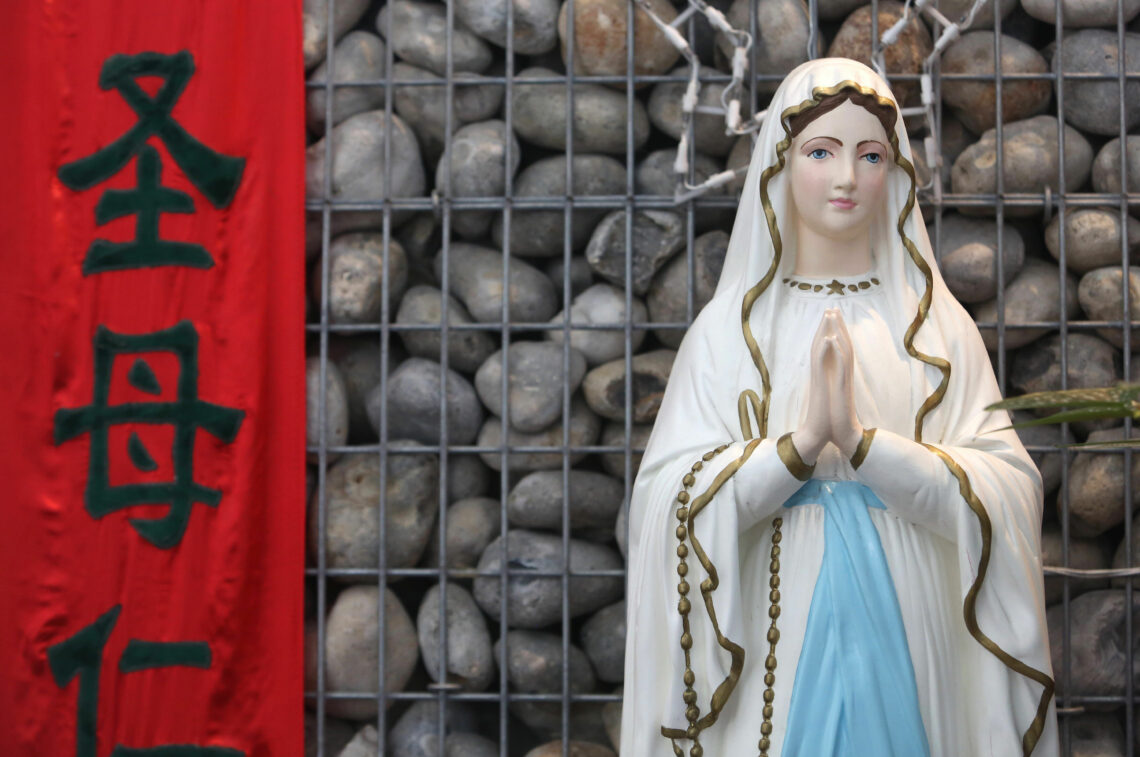 A statue of Mary and a Chinese banner