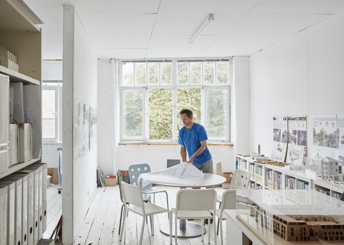 Man looking at plans in a minimalist Scandinavian office building