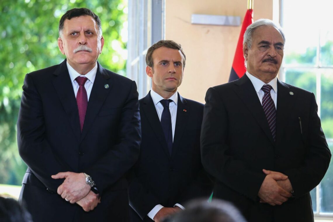 Libya’s two main leaders at July 2017 peace talks in ParisThe tension between Libya’s two key political figures – Fayez al-Sarraj (L) and General Khalifa Haftar (R) – was visible in July 2017 peace talks brokered by French President Emmanuel Macron