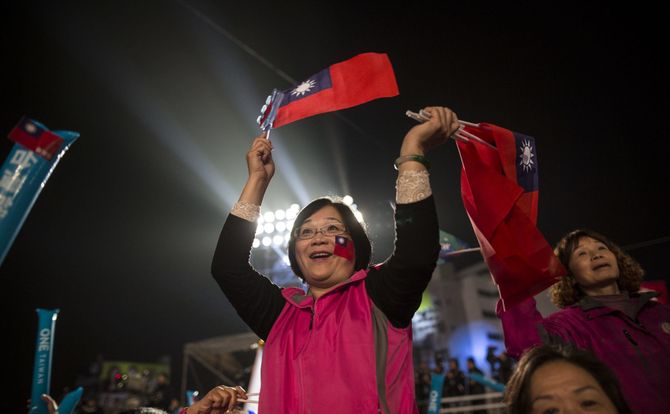 A Kuomintang supporter waves Taiwanese flags at an election rally