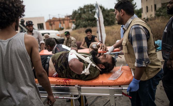 Wounded Libyan fighter is rushed to a hospital in Tripoli