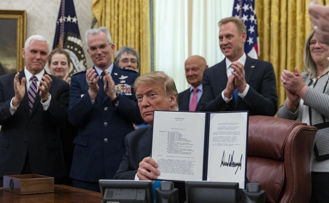 President Donald Trump shows his signature on a space force policy directive