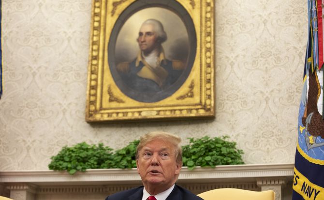 President Donald Trump beneath a portrait of George Washington in the Oval Office