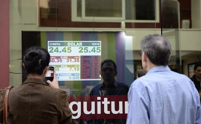 A picture of people watching information on a currency exchange board in the Argentine capital’s financial district Successes Argentina