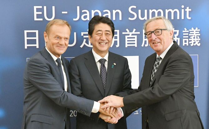 European Council President Donald Tusk, Japanese Prime Minister Shinzo Abe and European Commission President Jean-Claude Juncker shake hands after agreeing on a free-trade deal