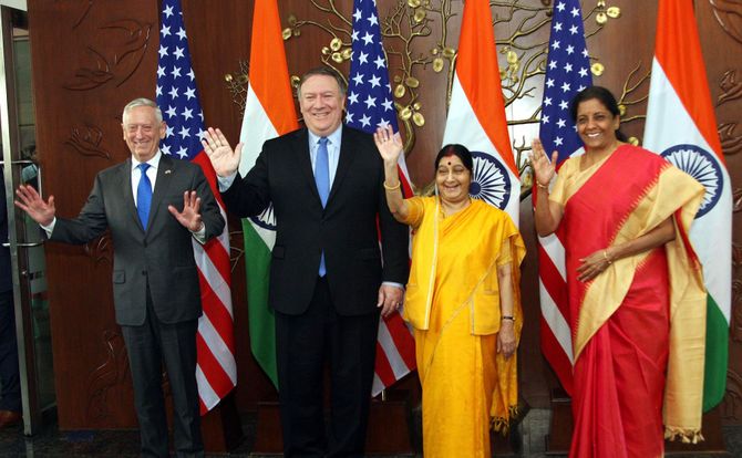 American and Indian defense and foreign ministers wave to photographers at a press event in September 2018