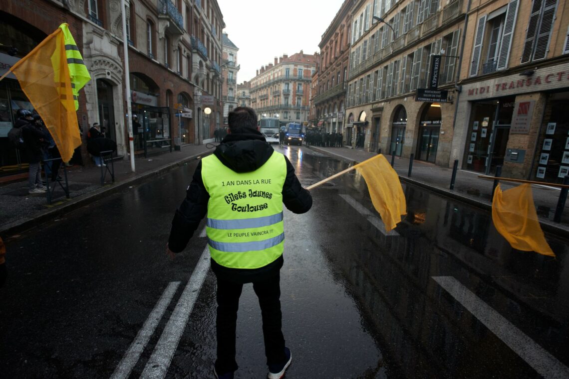 A Yellow Vest protestor faces off against riot police in France