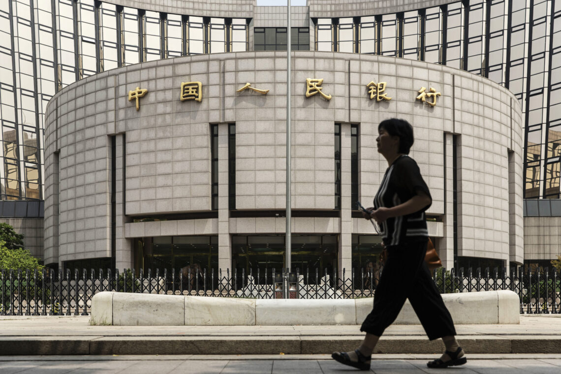 A pedestrian walks past the People's Bank of China (PBOC) headquarters in Beijing, China China growth forecasts