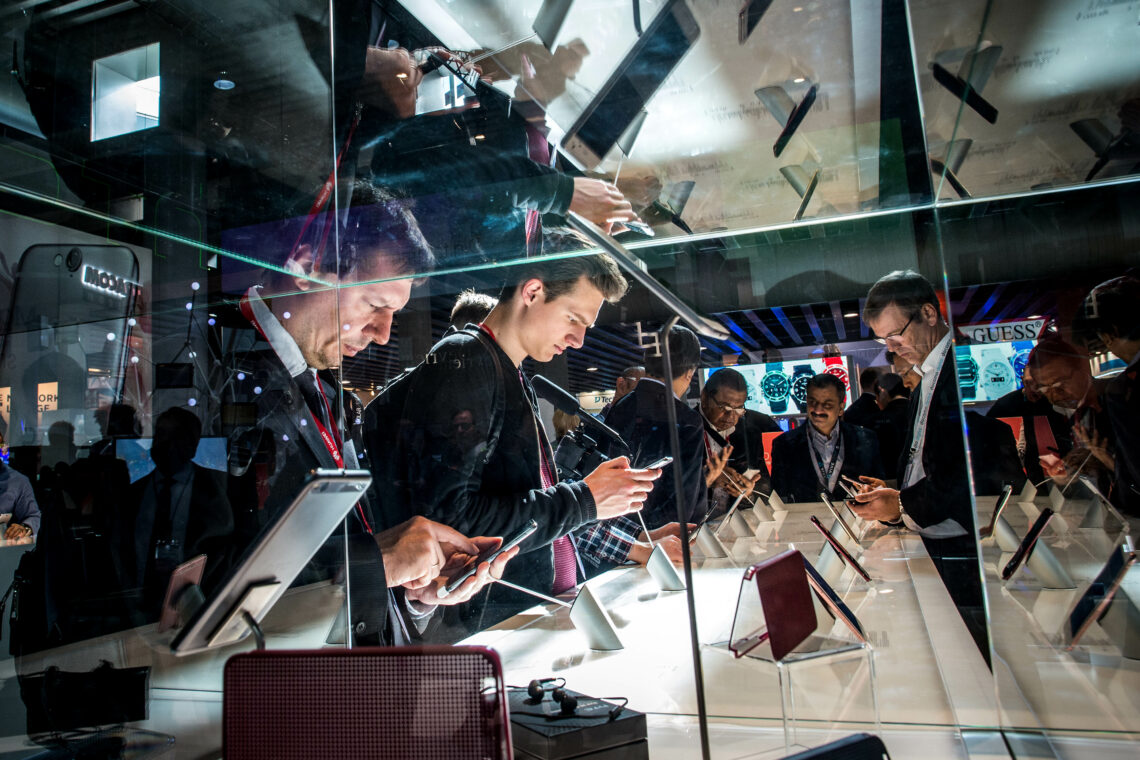 Attendees at the Mobile World Congress examine technology on display DMA European innovation