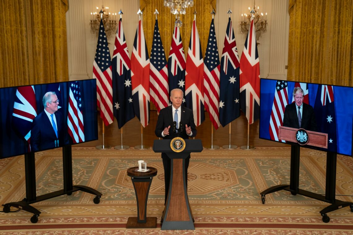 President Biden speaks about the AUKUS deal, flanked by screens showing Australian Prime Minister Scott Morrison and UK Prime Minister Boris Johnson