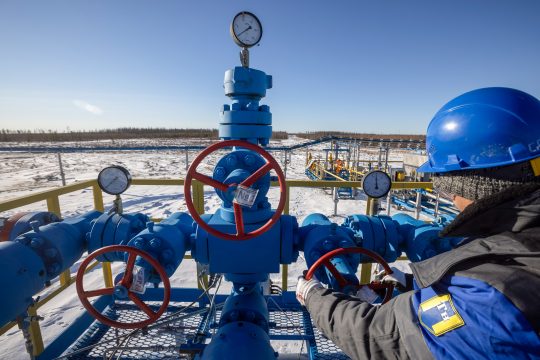 A Gazprom worker turns a valve wheel at a Russian gas well (Russia Europe gas)