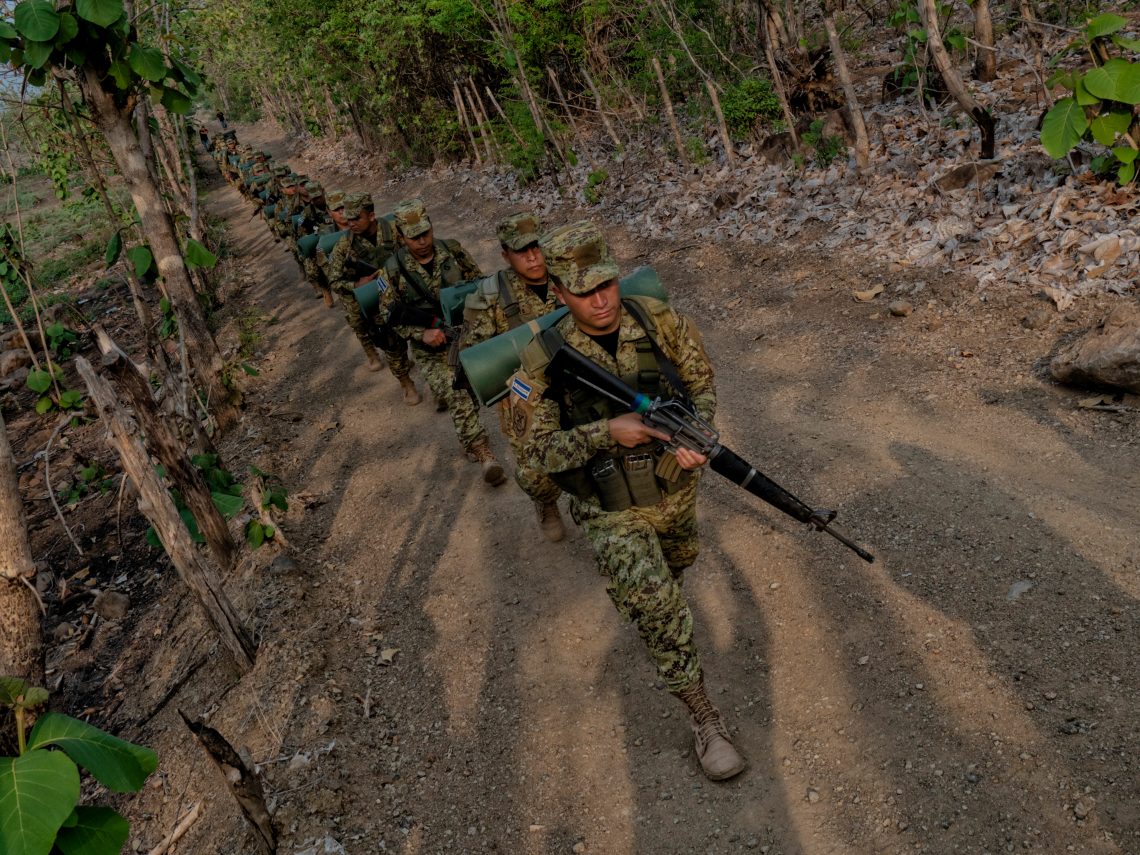 Salvadoran Army soldiers patrol a town