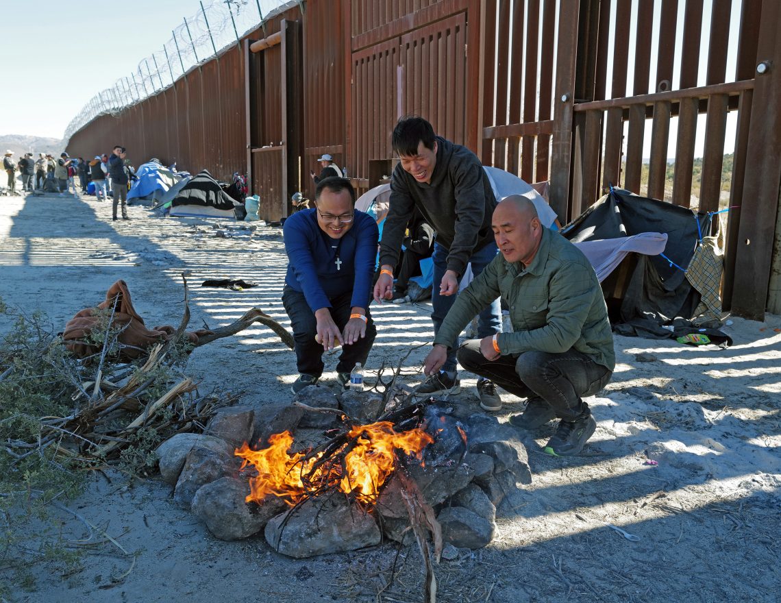 A group of men lighting a fire