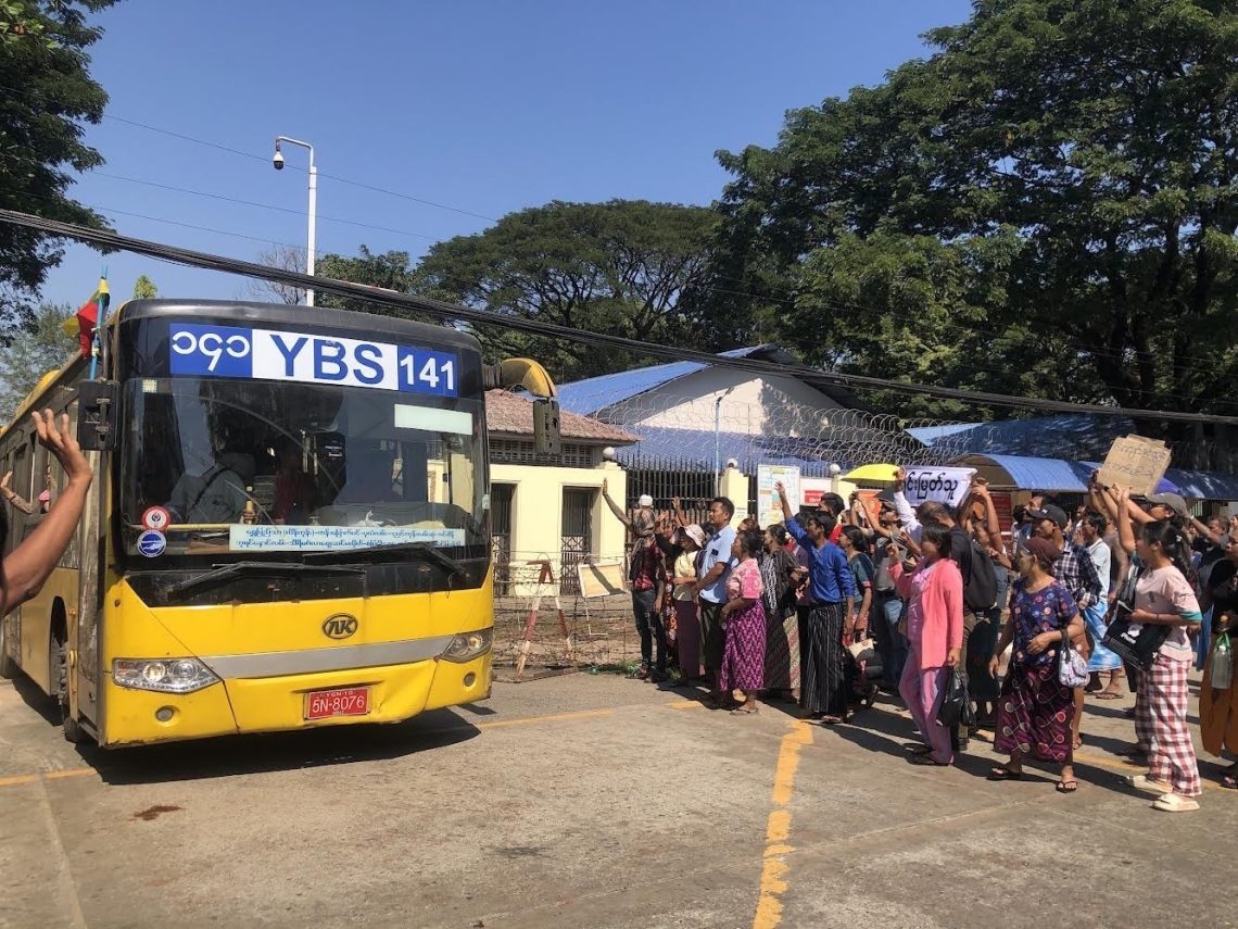 A group of people standing around a bus