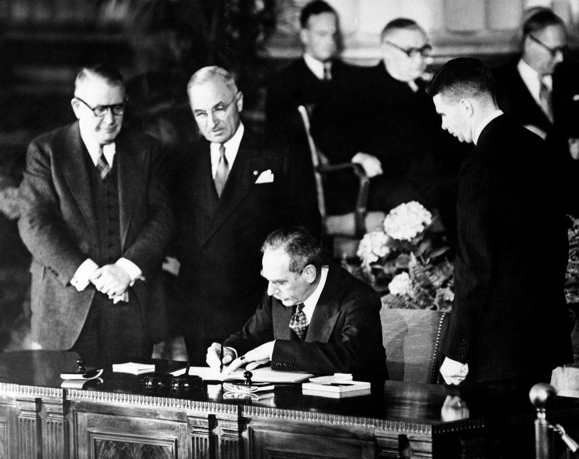 Dean Acheson, U.S. secretary of state, puts his name to the North Atlantic Treaty at the founding ceremony in the auditorium of the State Department in Washington D.C.
