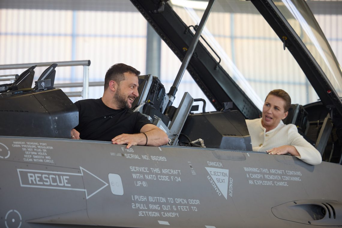 Ukrainian President Zelenskiy and Danish Prime Minister Frederiksen sit in the cockpit of an F-16 fighter jet at a Danish air base.
