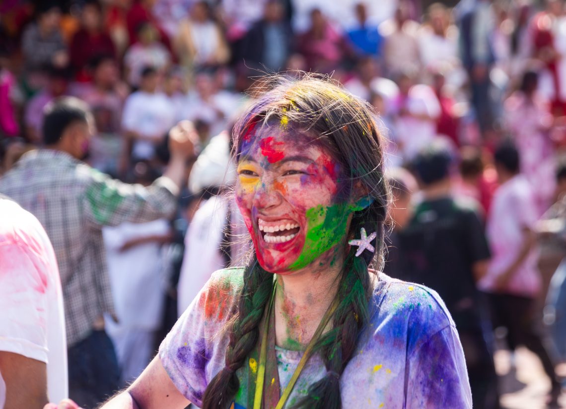 A woman in Kathmandu smeared with vermilion powder smiles during the Holi festival marking the victory of good over evil and symbolizing the arrival of the spring season.